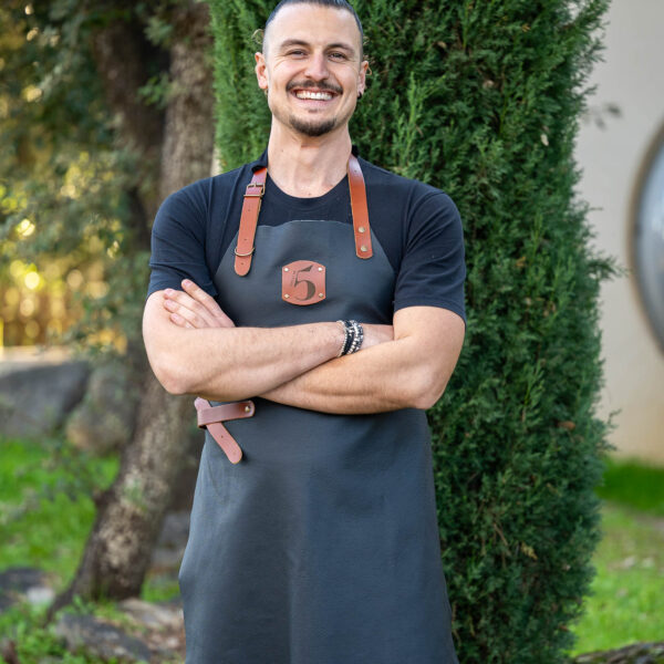 Chef wearing a black Chilli No. 5 apron with leather details