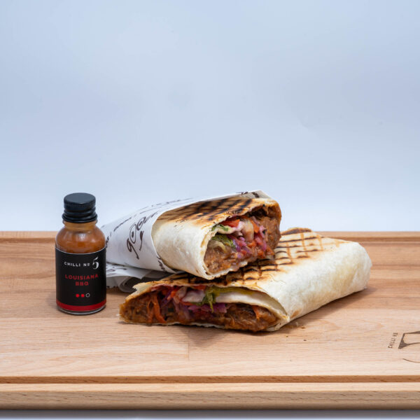 A Chilli No. 5 rectangular cutting board with a grilled wrap and mini bottle of Chilli No. 5 on it